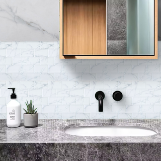 Azulejos autoadhesivos Mármol Nube estilo ladrillo instalados en pared de baño moderno.