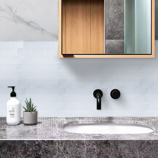Azulejos autoadhesivos Nube Clara estilo ladrillo instalados en pared de baño moderno.
