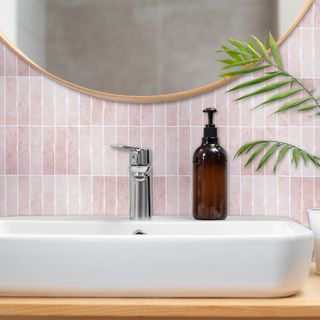 Azulejos autoadhesivos Rosa Antigua estilo columna instalados en pared de baño moderno.