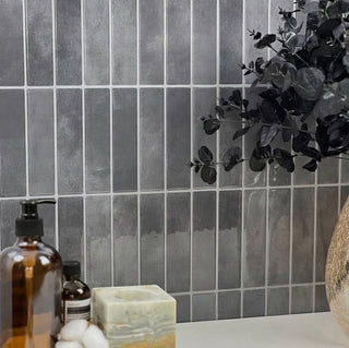 Azulejos autoadhesivos Ceniza Volcánica estilo columna instalados en pared de baño moderno.
